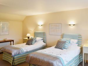 a hotel room with two beds in a room at Stable Cottage - Beaufort Estate in Belladrum