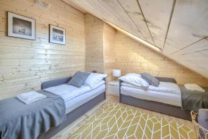 a room with two beds in a wooden cabin at Dom nad Bychowianką in Białogóra