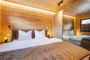 um quarto com uma grande cama branca e paredes de madeira em Bergwaldchalet Komfort em Schierke