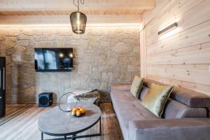 uma sala de estar com um sofá e uma parede de pedra em Bergwaldchalet Komfort em Schierke
