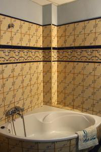 y baño con bañera y pared de azulejos. en Casa Aurora, en Carcabuey