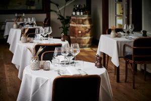 un grupo de mesas con copas de vino. en Hotel Strandly Skagen en Skagen