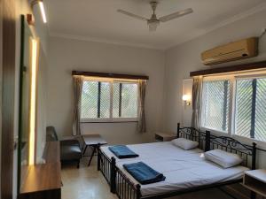 a bedroom with a bed and a desk and two windows at Vatika Homestay in Varanasi +19 photos
