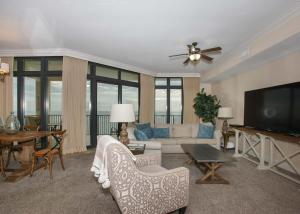 a living room with a couch and a flat screen tv at Oasis at Orange Beach 1103 in Orange Beach