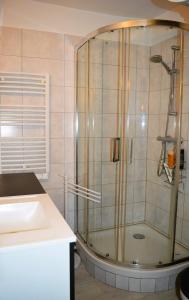 uma casa de banho com um chuveiro e um lavatório. em L'escapade - Logement les pieds dans l'eau à Luc em Luc-sur-Mer