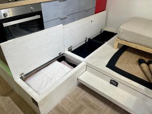 an open drawer in a small kitchen with a bed at Oikiastudios in Patra