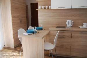 a kitchen with two chairs and a table with wine glasses at Villa Veell - tylko 4 minuty od pięknej szerokiej plaży in Pobierowo