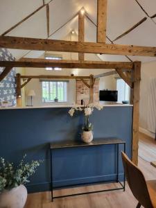 a room with a blue wall and a table with flowers at The Woodshop in Darlington