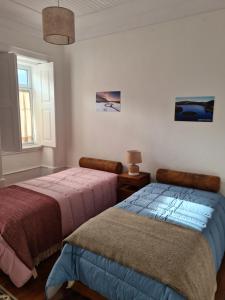 two beds sitting next to each other in a bedroom at Glaciar Guest House in Manteigas