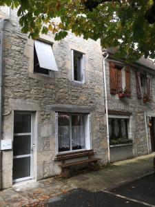 un bâtiment en pierre avec un banc devant lui dans l'établissement La maison du Tour de Ville, à Cajarc