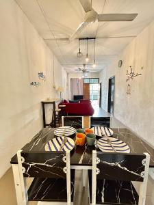 a dining room with a table with plates on it at Home33#2pax#wifi&netflix#NearAeonAlma#5kmIconCity#5kmtoSimpangAmpat in Bukit Mertajam