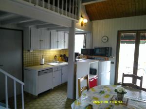 eine Küche mit einem Tisch und einem weißen Kühlschrank in der Unterkunft a l'orée de tronçais in La Perche