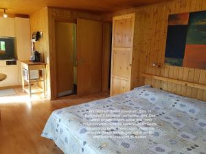 a bedroom with a bed and a kitchen at Chalet Florida in Bürchen