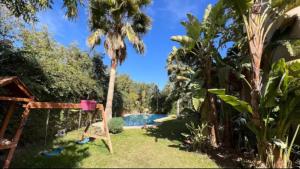 een achtertuin met een palmboom en een schommel bij Villa Jasmina Targa in Marrakesh