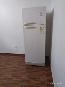 einen weißen Kühlschrank in einem Zimmer mit Holzboden in der Unterkunft Hostel el Amanecer in Puerto Iguazú + 37 Fotos
