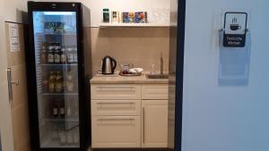 a kitchen with a refrigerator filled with lots of alcohol at Hotel Apfelrot in Erding