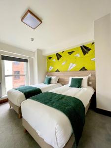 a hotel room with two beds and a painting on the wall at The Norseman Temple Bar in Dublin