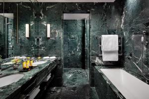 a black bathroom with two sinks and a bath tub at The Gritti Palace, a Luxury Collection Hotel, Venice in Venice