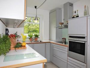 a kitchen with white appliances and a counter with vegetables at Haus Pünktchen in Tinnum