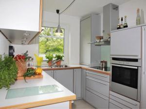 eine Küche mit weißen Geräten und einer Theke mit Gemüse in der Unterkunft Haus Pünktchen in Tinnum