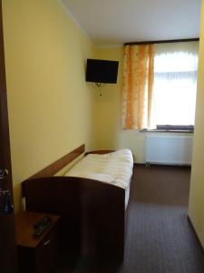 a small bedroom with a bed and a window at Hostel Miłosz in Grabowiec