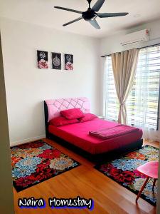 a bedroom with a pink bed and a rug at Naira Homestay Kota Bharu ,Wakaf Che Yeh 4 Bilik 3 Aircond in Kota Bharu
