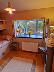 a room with a bed and a window and a table at Fyne Byre Cottage - Barn Conversion with Hot Tub in Cairndow