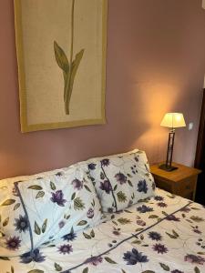 um quarto com uma cama com colcha floral em Casa Pedro in Salema - Oceanview & beach em Salema