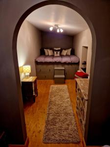 an arched room with a bed and a table at Fyne Byre Cottage - Barn Conversion with Hot Tub in Cairndow