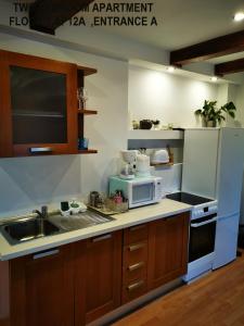 a kitchen with a sink and a microwave at Black and White Apartments in Bucharest