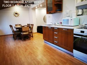 a kitchen with a wooden floor and a table with a microwave at Black and White Apartments in Bucharest