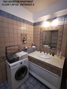 y baño con lavadora y lavamanos. en Black and White Apartments, en Bucarest