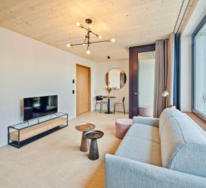 a living room with a couch and a tv at Liv Suites - Self Check-in in Lucerne