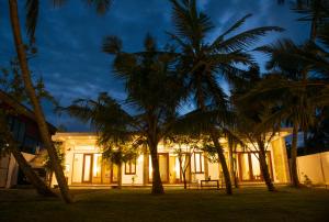 um edifício com palmeiras em frente em Hiru Lagoon Negombo em Negombo