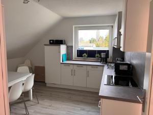 een keuken met witte kasten en een raam bij Großzügige 3 ZKB mit 80m² in Wilhelmshaven