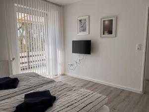 ein Schlafzimmer mit einem Bett und einem TV an der Wand in der Unterkunft Großzügige 3 ZKB mit 80m² in Wilhelmshaven