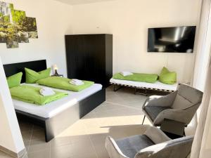1 Schlafzimmer mit 2 Betten mit grünen Kissen und einem Stuhl in der Unterkunft Meißner Elb-Domizil 2 in Meißen