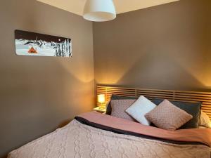 um quarto com uma cama com almofadas em LE RUCHER DE LA VIGNETTE em Le Grand-Bornand