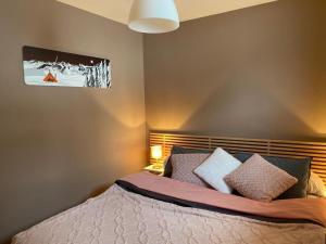 a bedroom with a bed with pillows on it at LE RUCHER DE LA VIGNETTE in Le Grand-Bornand