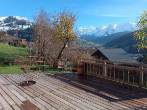 a wooden deck with a view of the mountains at LE RUCHER DE LA VIGNETTE in Le Grand-Bornand