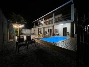 una casa con piscina por la noche en Recanto Pé na Areia SC en Palhoça