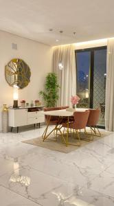 uma sala de estar com uma mesa e cadeiras e um espelho em Spacious new 2 bedroom Apt-in amazing location B6 em Riyadh