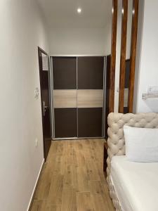- une chambre avec un lit et une porte coulissante en verre dans l'établissement Villa i SPA Stević, à Veliko Gradište