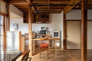 een keuken met een tafel en stoelen en een koelkast bij 神倉書斎 [Kamikura-Hideaway] in Shingu