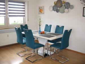 comedor con mesa y sillas azules en Diamond house deluxe 5 Koblenz, en Coblenza