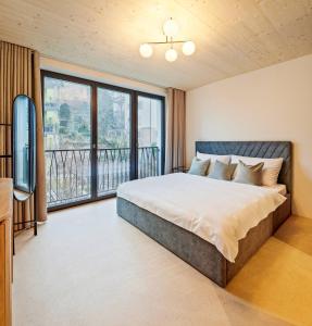 um quarto com uma cama grande e uma varanda em Liv Suites em Lucerna