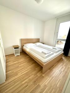 ein Schlafzimmer mit einem großen Bett und Holzboden in der Unterkunft FORSTHAUS 27 FREE GARAGE in Wien