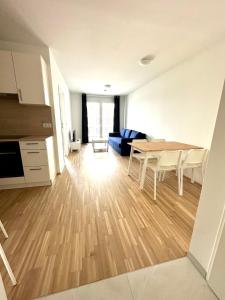 een keuken en een woonkamer met een tafel en stoelen bij FORSTHAUS 27 FREE GARAGE in Wenen