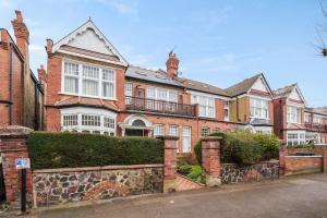 una grande casa in mattoni rossi con un muro di pietra di Beautiful one bed garden flat in Muswell hill a Londra