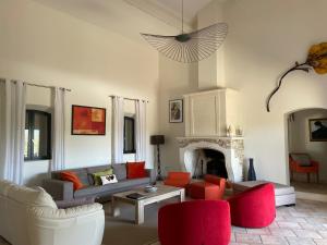 sala de estar con sillas rojas y chimenea en La Cath - Villa avec piscine - Gordes en Gordes